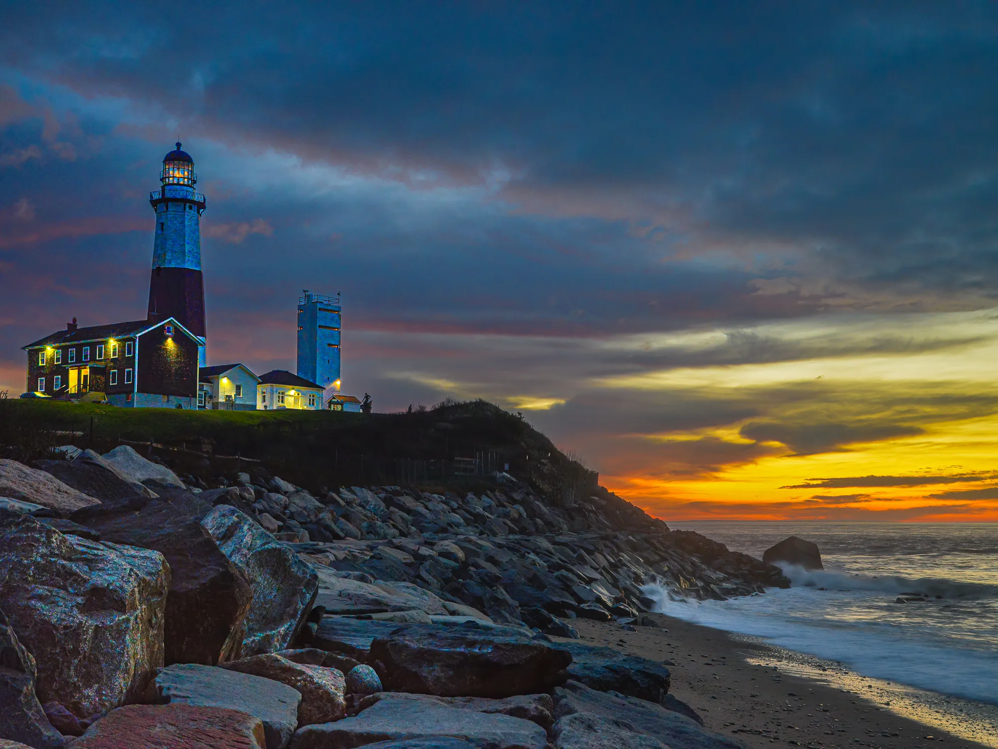 A lighthouse with rocks in the foreground adding depth and leading the eye to the subject