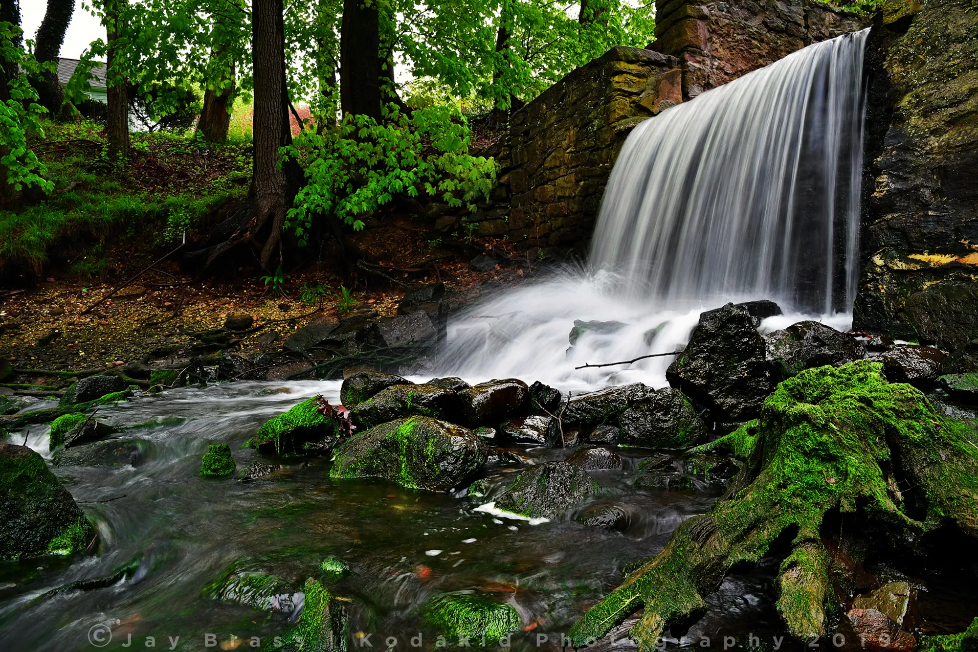 A waterfall with foreground rocks that add depth and lead toward the main subject
